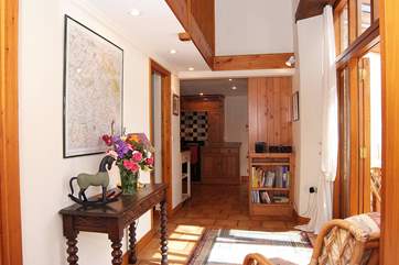 This cottage is very spacious and light. This is the view from the sitting-room along the corridor to the kitchen, with the sun-room and dining-room to the right.