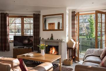 The sitting area of the open-plan living-room has doors out to the waterside terrace.