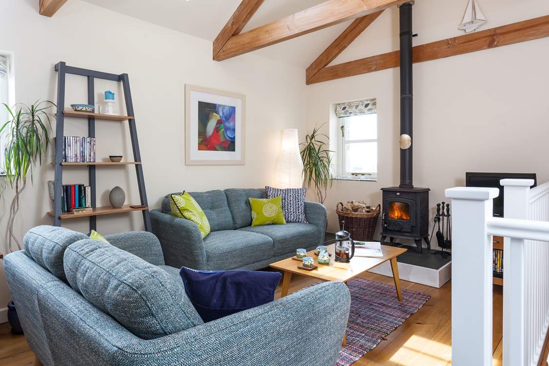 The open plan living-room is a sociable place to relax or dine. Stairs lead down to the bedrooms and bathroom.