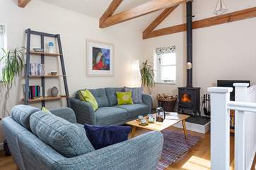 The open plan living-room is a sociable place to relax or dine. Stairs lead down to the bedrooms and bathroom.