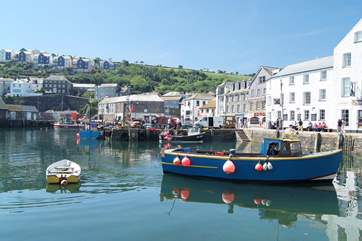 Fishing boats pull up at the harbour in Mevagissey to unload.