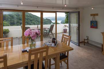 The patio is approached through floor to ceiling glass doors and windows.