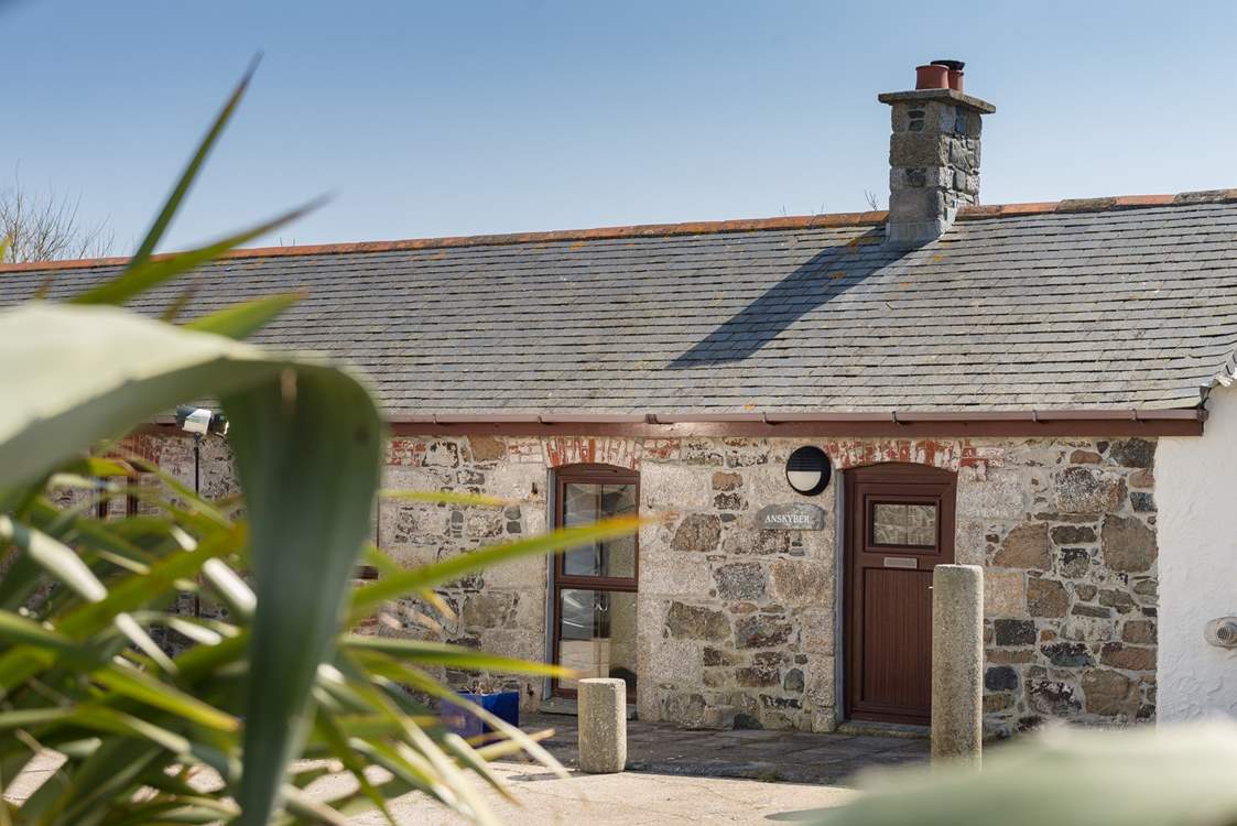 Anskyber is a single storey cottage that sits in a large open courtyard, with parking to the front.