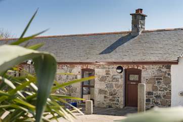 Anskyber is a single storey cottage that sits in a large open courtyard, with parking to the front.