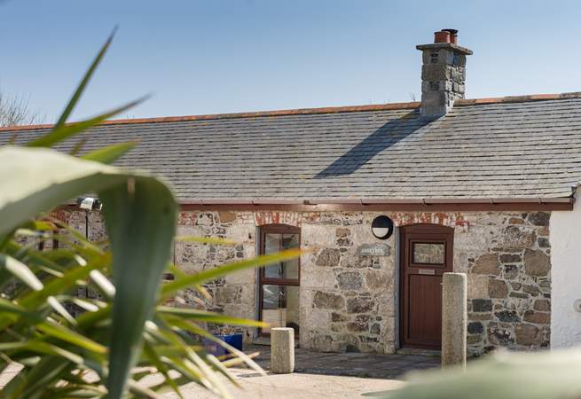 Anskyber is a single storey cottage that sits in a large open courtyard, with parking to the front.