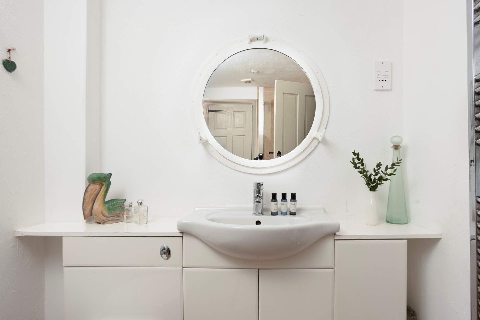 The light and airy shower-room has a port hole mirror.