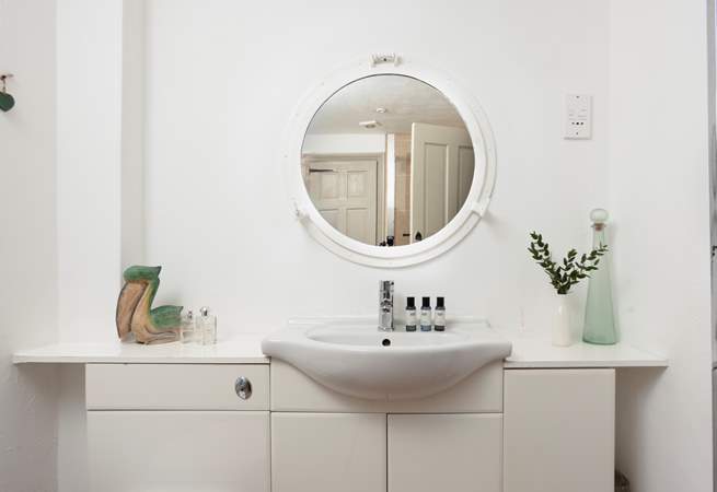 The light and airy shower-room has a port hole mirror.