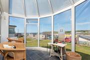 Chill out in the conservatory, enjoying the view down to the beach.