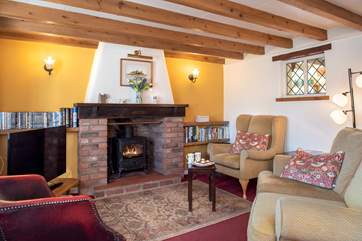 The cosy sitting-room is traditionally furnished and has a lovely wood burning stove.