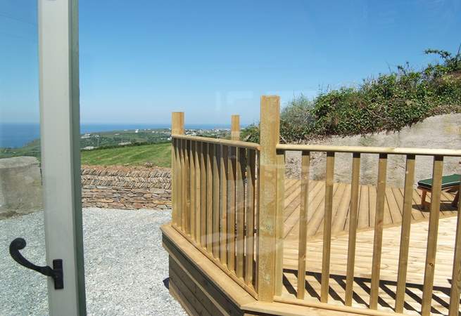 The view from the bedroom window looks out onto the decked area and has sea views.
