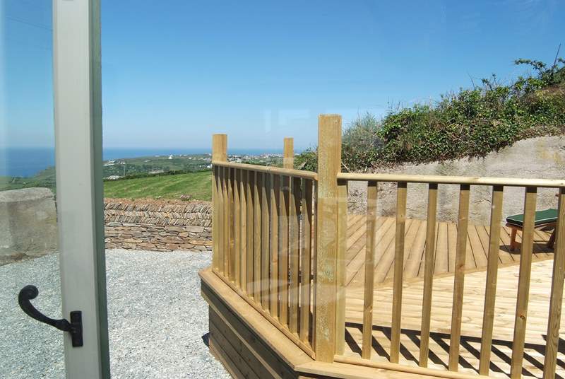 The view from the bedroom window looks out onto the decked area and has sea views.