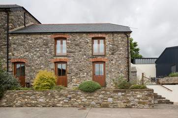 The front of the cottage with the patio at the top of the stairs.