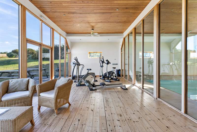 The small gym is equipped with a rowing machine, running machine, elliptical trainer, and an exercise bike.