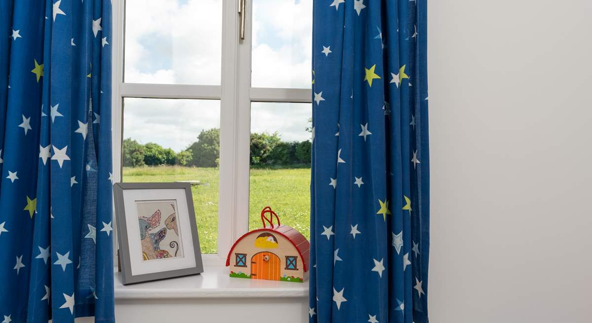 The single bedroom overlooks the field behind.