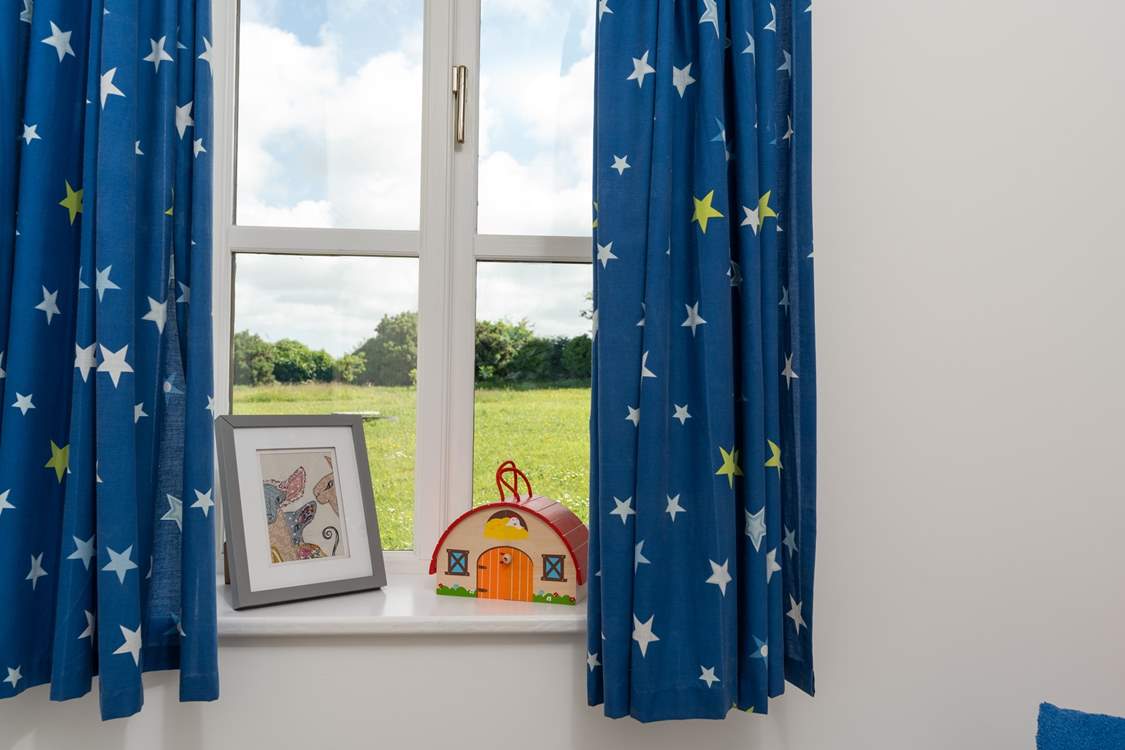 The single bedroom overlooks the field behind.