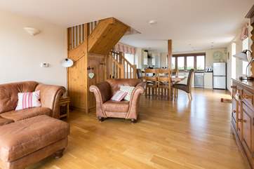 The sitting-area has luxurious antiqued leather sofas, the dining-table is in the middle of the room and the kitchen is at the far end.