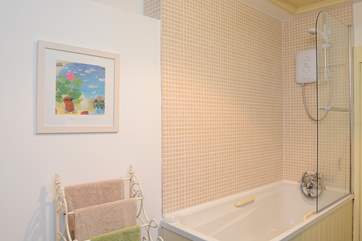 In the bathroom, there is a step up to the bath which is fitted with an electric shower.