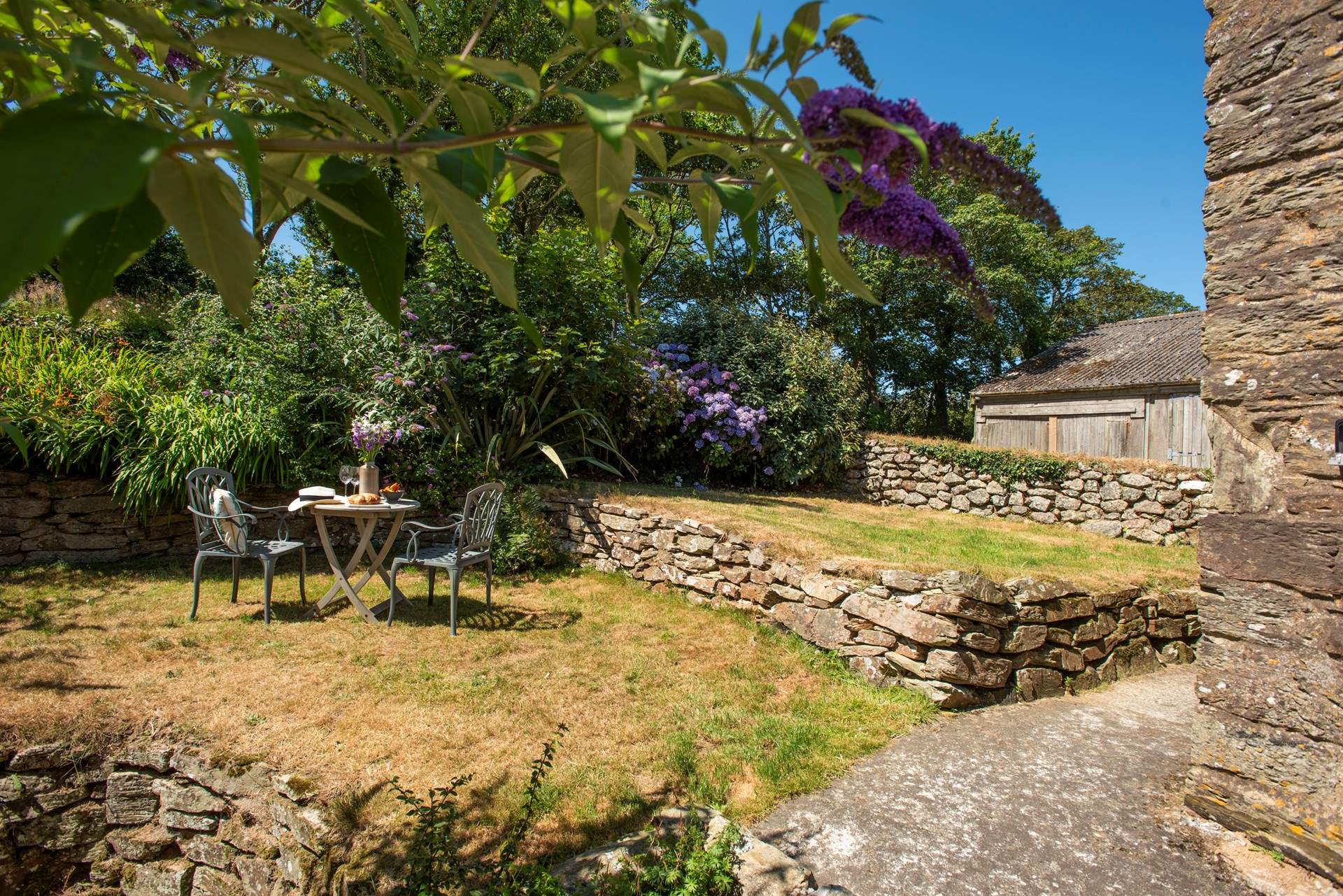 The garden is terraced and has a slope at the bottom.