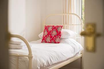 The combinaton of fresh white cotton sheets, colourful cushions and pictures make this a very special seaside home-from-home.