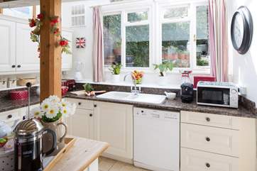 The view from the kitchen sink looks out to the garden and water beyond.