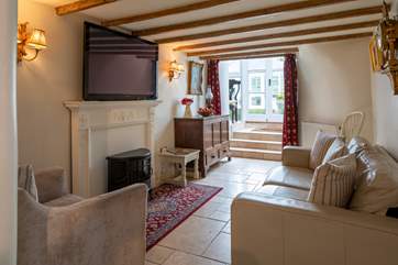 The snug room (second sitting-area) leads from the kitchen through to the garden and conservatory beyond).
