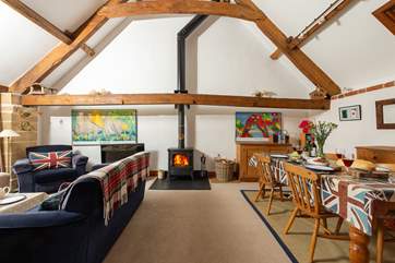 The open plan living/dining-area is separated from the kitchen-area by a low beam.
