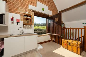This window opening is a feature of the original barn when it really was a hayloft. This listed building has this low sill so do keep closed when children are staying.