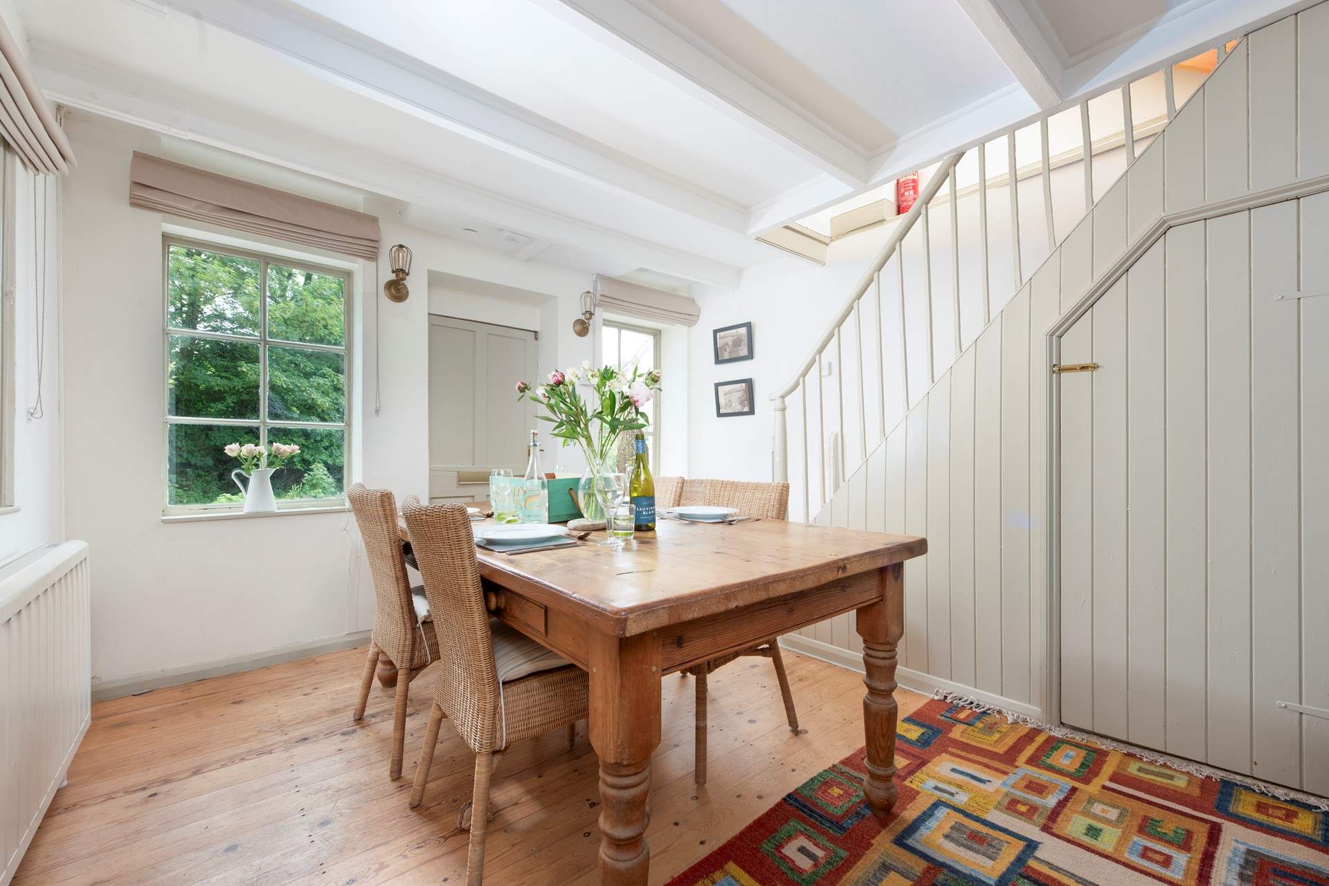 The polished pine dining-table sits at one end of the open plan living-room.