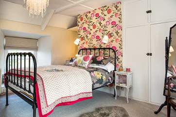 The master bedroom has a lovely bedstead adorned with throws and cushions.