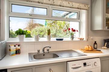 The kitchen looks out onto the back garden and patio.