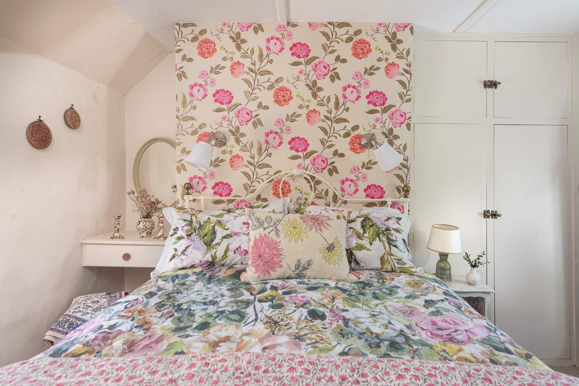 The master bedroom has a lovely bedstead adorned with throws and cushions.