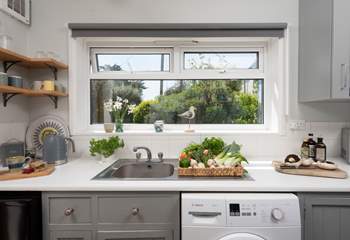 The kitchen looks out onto the back garden and patio.