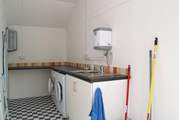 The separate utility-room is located behind the cottage next door.