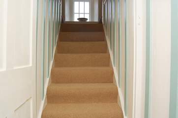 Stairs lead up to the bedrooms on the right-hand side and the spacious shower-room on the left.