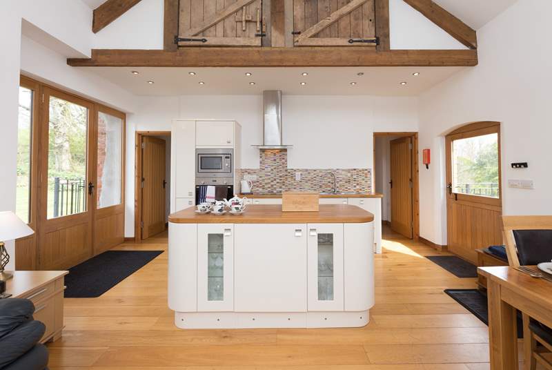 The stunning open plan living accommodation is double height, with access to the level private garden at the back of the barn