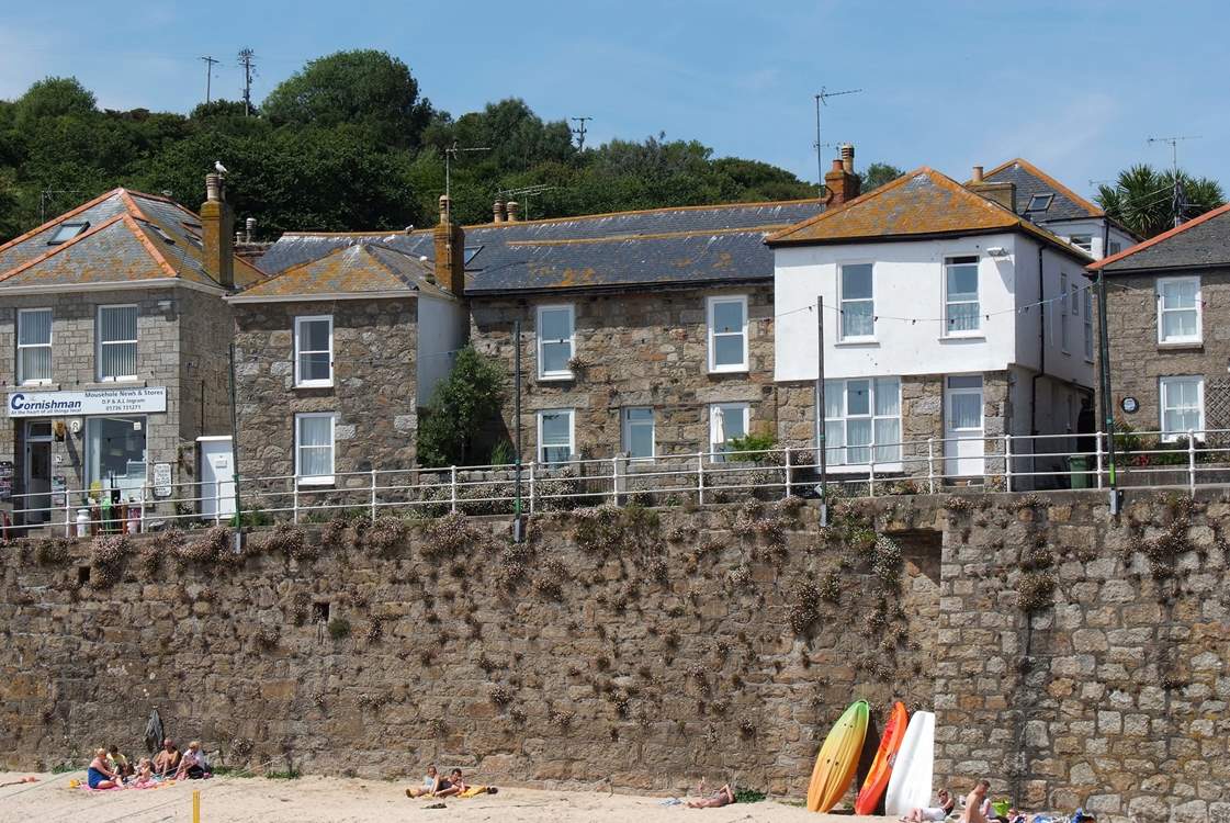 Pender Cottage is the cottage to the right-hand side of the shop and has a white gate.