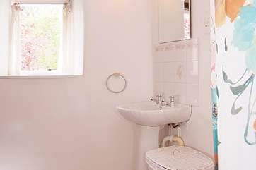 The bathroom has a bath with a fitted shower.