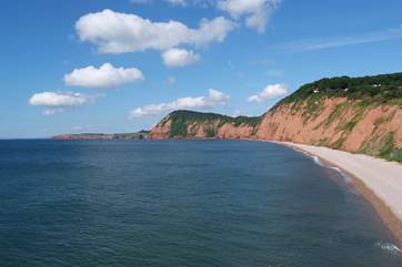 The view to the west from the clifftops at Sidmouth - a pebble beach with sand at low tide.