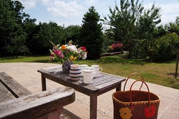 The sunny patio overlooks the beautiful garden and the panoramic views beyond it. Take care of the drop down to the lawn.