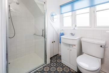 The bathroom has a large shower cubicle.