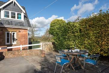 The patio is a sun-trap, sheltered by the large hedge.