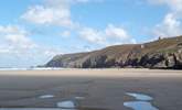 Nearby Chapel Porth beach at low tide, with iconic mine buildings perched on the cliffs above. - Thumbnail Image