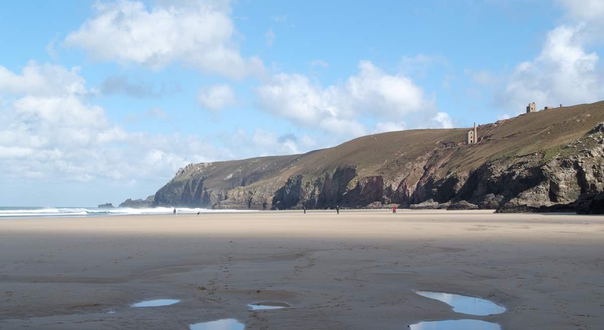 Nearby Chapel Porth beach at low tide, with iconic mine buildings perched on the cliffs above.