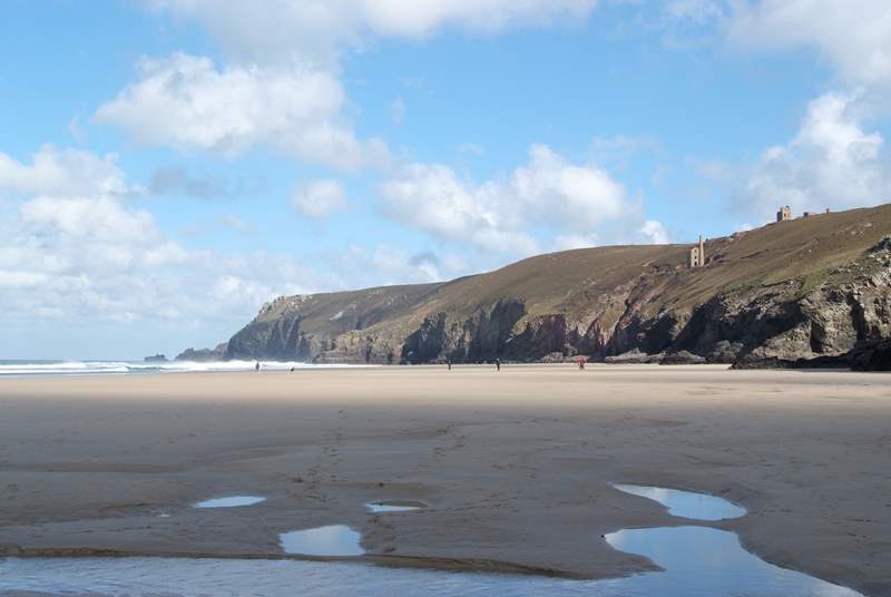 Nearby Chapel Porth beach at low tide, with iconic mine buildings perched on the cliffs above.
