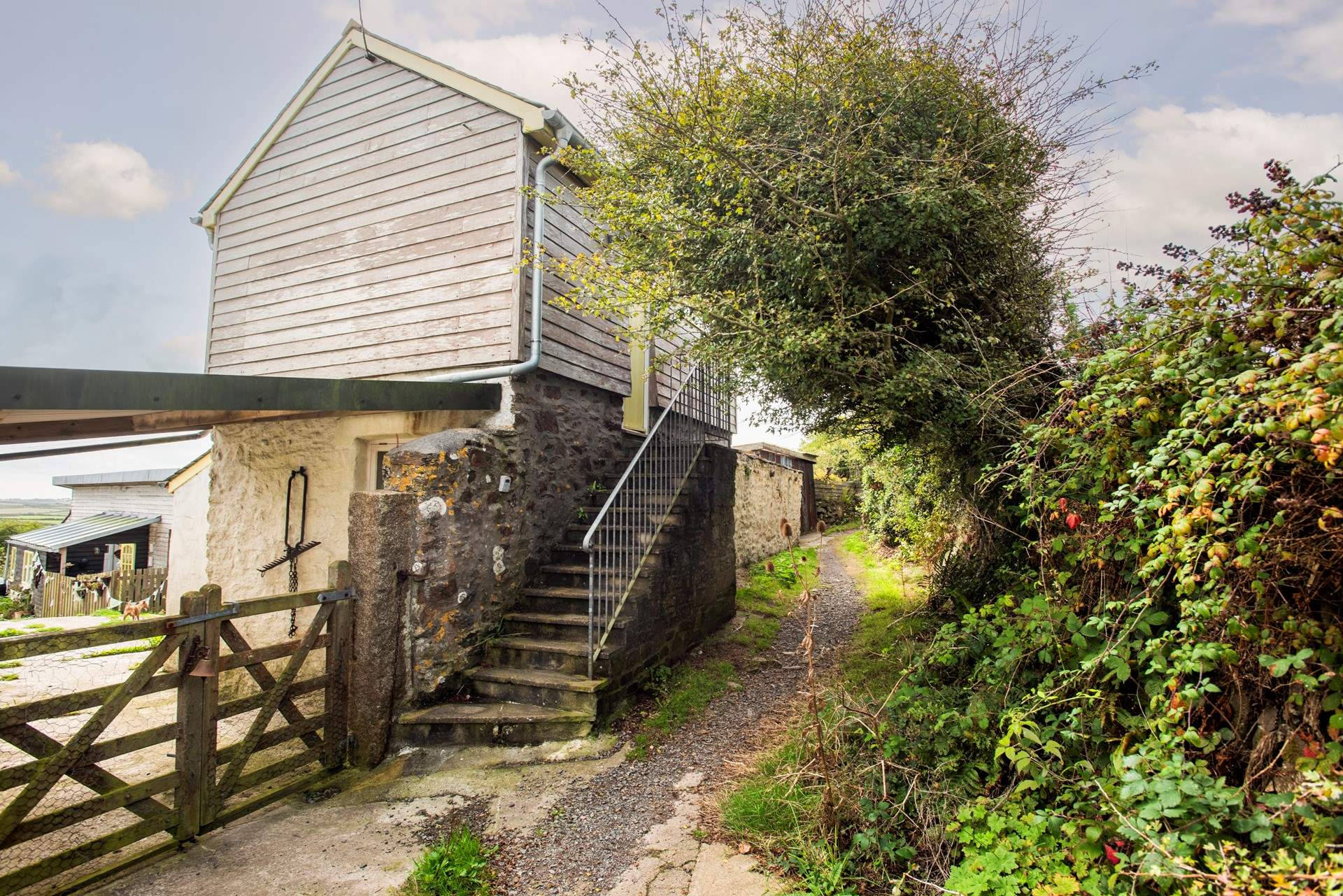 Steps access the cottage and the adjoining footpath leads up to the top of the Beacon.