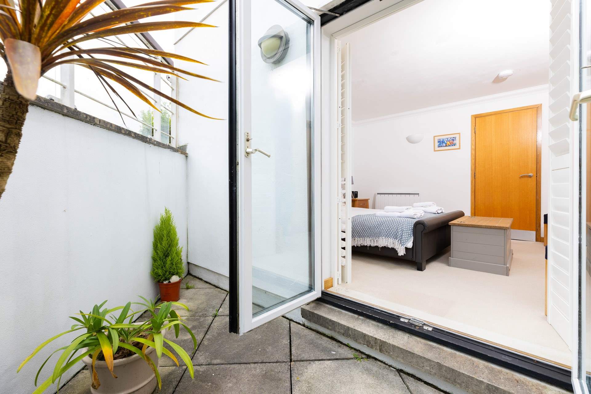 French doors from Bedroom 1 lead out onto a little courtyard.