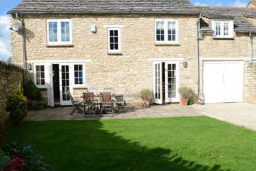 Two sets of French windows lead out onto the patio and enclosed garden.