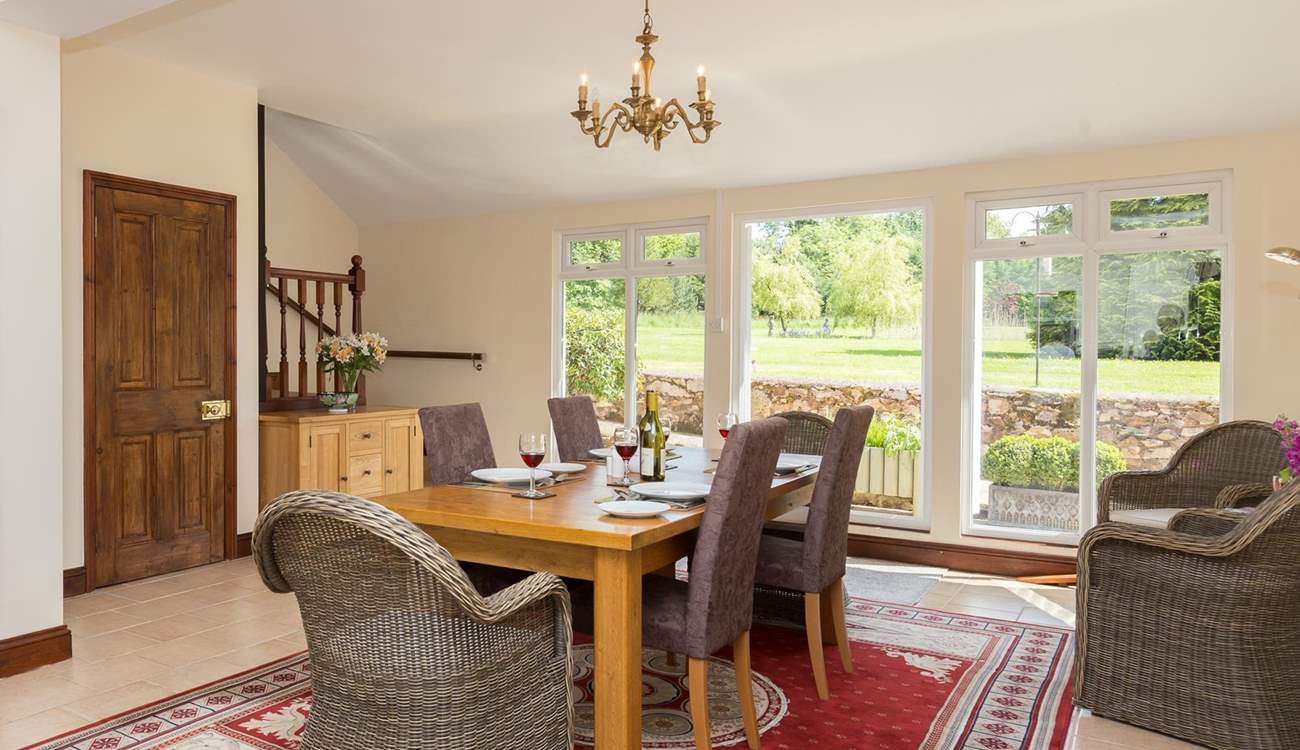 The spacious kitchen/dining-room looks out over the gardens. The stairs in the corner lead to the living-room.