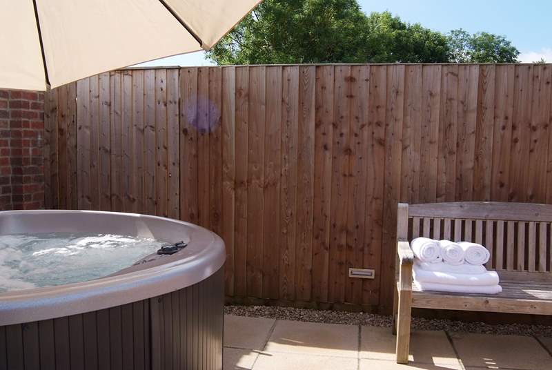 Indulge in the hot tub or the sauna next to it (just out of the picture), in this sheltered and private corner of the garden.
