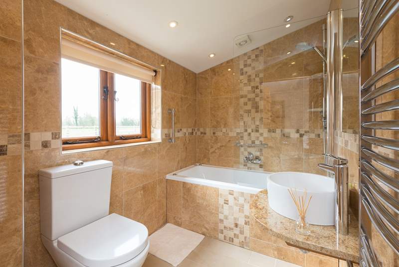 The en suite bathroom is beautifully designed with a spa bath as well as the shower.